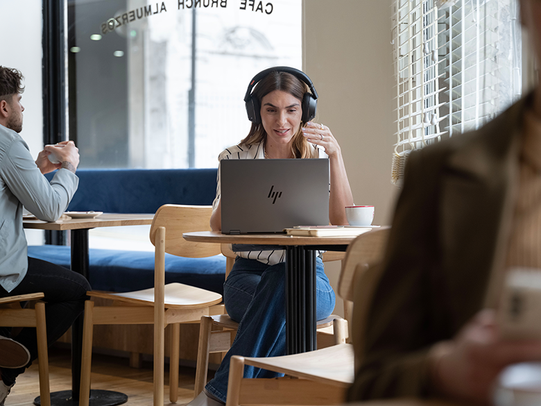 Videoanruf mit Laptop und Headset im Café