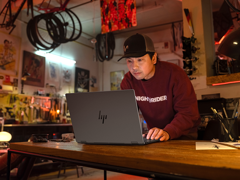 Focused Laptop Work In Bike Shop